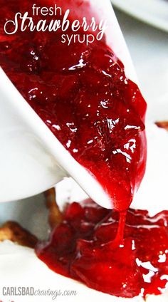 fresh strawberry syrup being poured into a white bowl