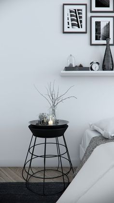 a black table with candles on it in front of a white wall and some pictures