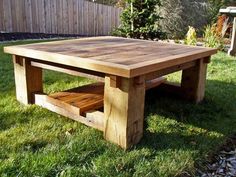 a wooden table sitting on top of a lush green field