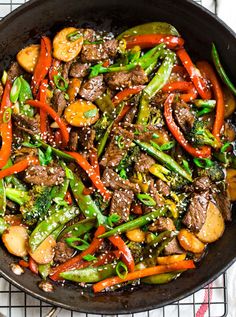 stir fry with beef, broccoli and carrots in a skillet on a wire rack