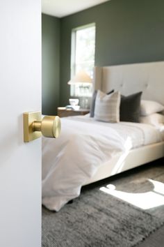 an open door leading to a bedroom with a bed in the background and carpet on the floor