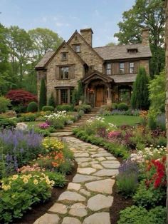 a stone path leading to a house surrounded by flowers