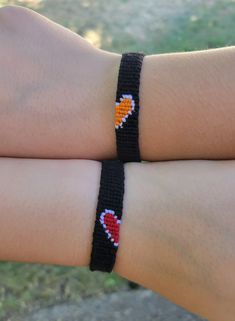 two people wearing bracelets that have hearts on each one and an orange heart on the other