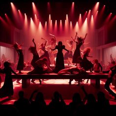 a group of people dancing on stage with red lights