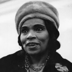 a black and white photo of a woman wearing a hat