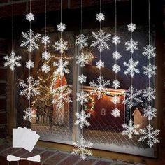 snowflakes hanging from the side of a window in front of a brick building