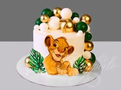 the lion king cake is decorated with gold, green and white decorations on top of it