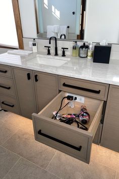 an open drawer in the middle of a bathroom counter