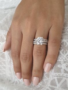 a woman's hand with two engagement rings on it