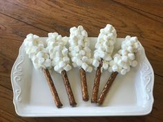 there are marshmallows on sticks in the tray