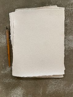 a piece of paper with a pencil on top of it next to some white papers