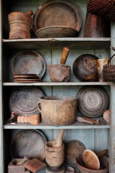 an old wooden shelf filled with pots and pans