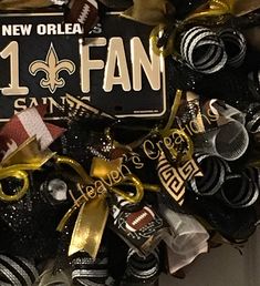 the new orleans saints football wreath is decorated with black, gold and white streamers