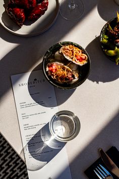 plates of food on a table with utensils and wine glasses next to them