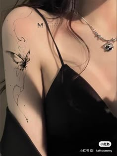 a woman with a butterfly tattoo on her arm and shoulder is posing for the camera