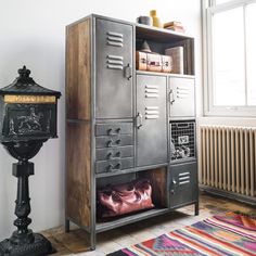 a large metal locker next to a lamp in a room with a rug on the floor