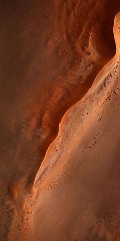 an aerial view of sand dunes in the desert with water flowing down them and dirt on the ground