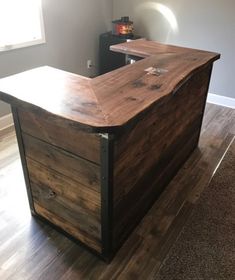 a wooden counter top sitting on top of a hard wood floor next to a window