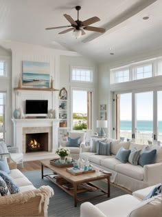 a living room filled with furniture and a fire place in front of a window overlooking the ocean