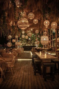 an outdoor restaurant with wooden tables and wicker lamps hanging from the rafters above