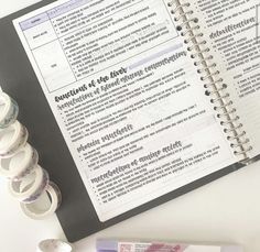 an open notebook with rolls of toilet paper on top of it next to a roll of tape