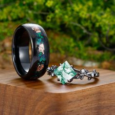 a black ring with green and white flowers on it sitting on top of a wooden table