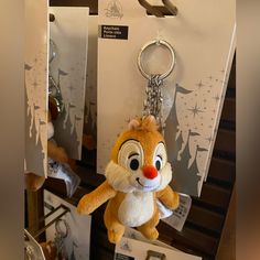 a stuffed animal keychain is hanging from a display case with other items in the background