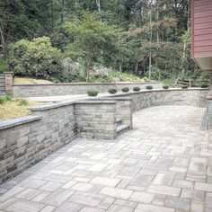 an outdoor patio with stone walls and benches