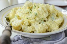 a white bowl filled with potato salad on top of a table