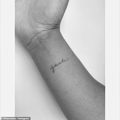 a woman's arm with a small tattoo on it that reads, love in cursive writing