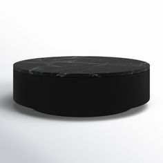 a round black marble table on a white background