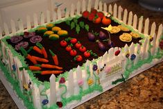 a cake that is sitting on top of a table with carrots, radishes and other vegetables