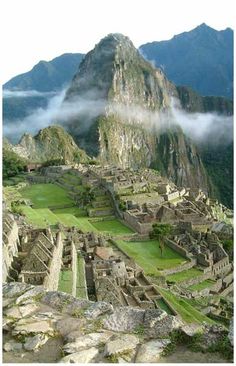 an ancient city surrounded by mountains and clouds