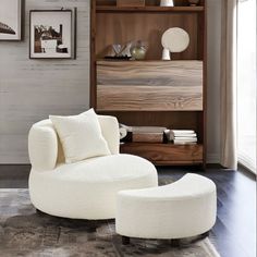 a living room with a white chair and ottoman in front of a bookshelf