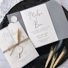 the wedding stationery is laid out on a black plate and decorated with twine