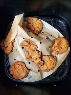 chocolate chip cookies are sitting on top of a paper bag in the air fryer