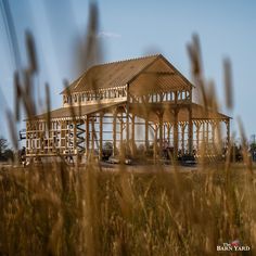 a house under construction in the middle of a field with lots of tall grass around it