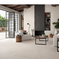 a living room filled with white furniture and lots of glass doors leading to an outside patio