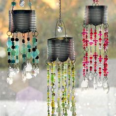 three tin can wind chimes hanging on a window sill with beads and crystals