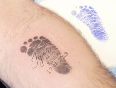 a close up of a person's arm with a baby foot print on it