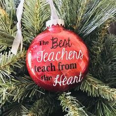 the best teachers teach from the heart ornament hanging on a christmas tree branch