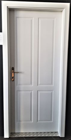 an open white door in a room with black walls and tile flooring on the ground