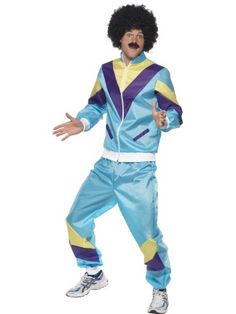 a man in an afro wig and blue pants is standing with his hands out to the side