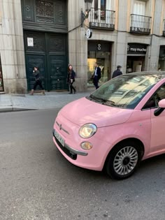 a pink car is parked on the street