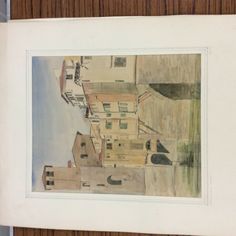 a watercolor painting on paper of a city street and buildings next to the ocean