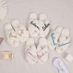 several personalized slippers are laid out on a bed