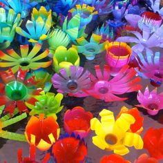 there are many colorful plastic flowers on the table