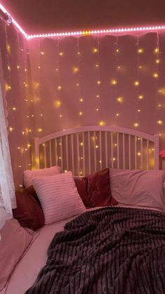 a bed that has some lights on the wall above it