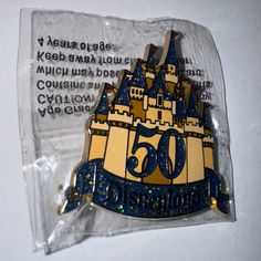 there is a pin with the number 50 on it in front of a plastic bag