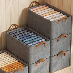 three gray storage bins with wooden handles and dividers on the wall next to each other